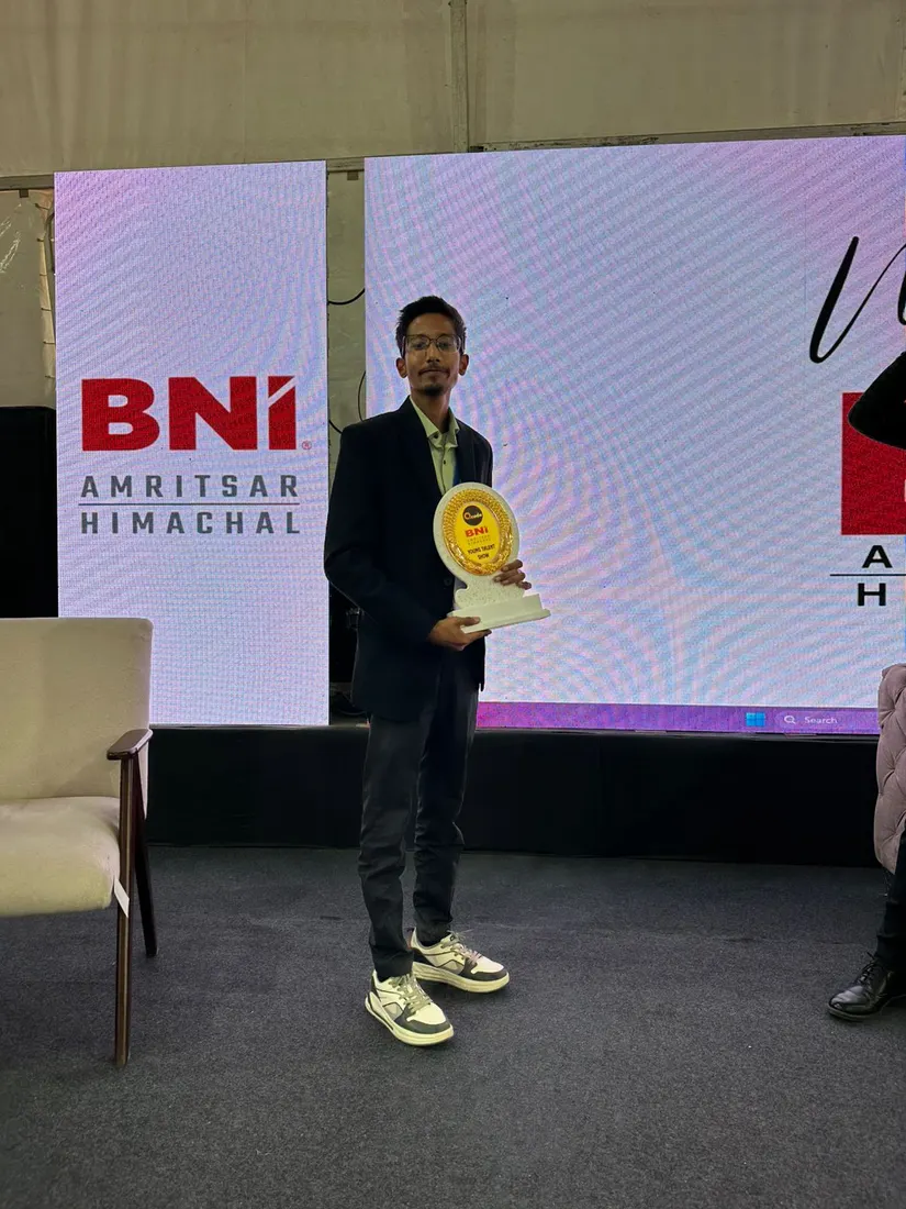 Sarwang Shukla holding a memento on stage at a BNI Amritsar Himachal event